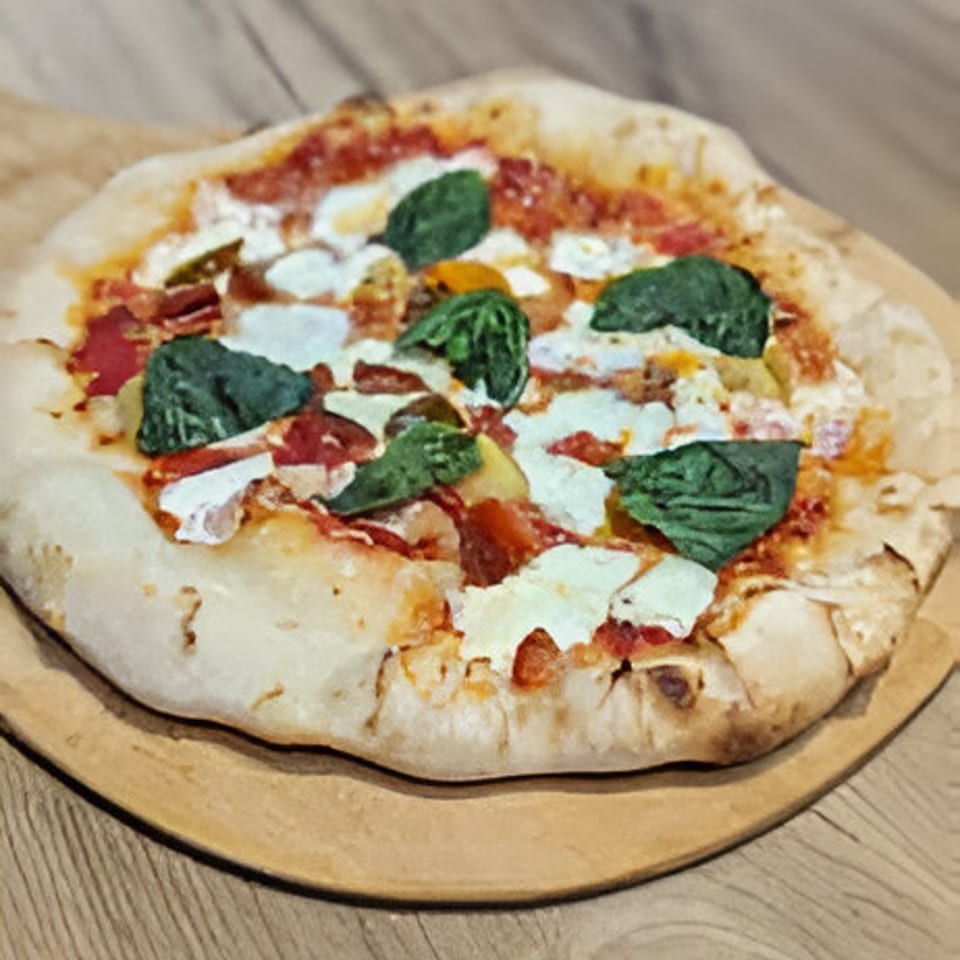 Mercer Village Pizza's Margherita pizza with fresh basil, mozzarella, and tomato sauce on a wooden peel.